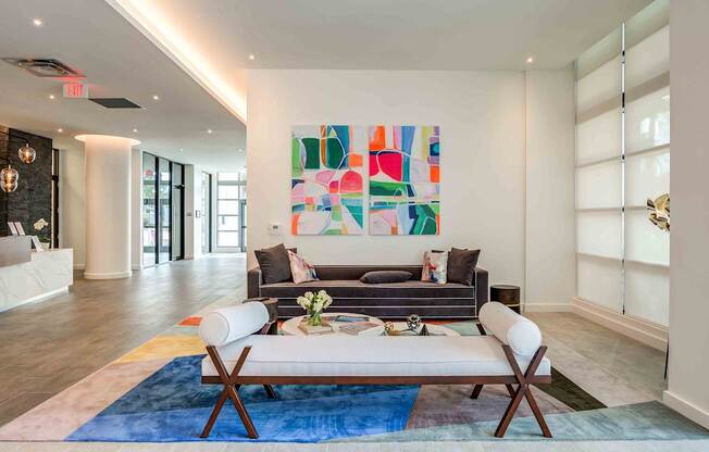 A modern living room with a large abstract painting on the wall.