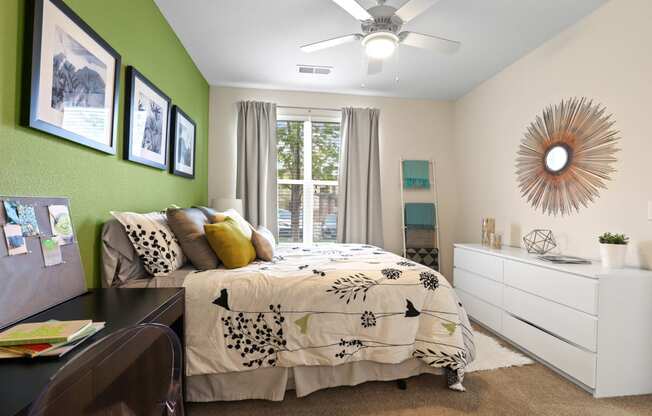 a bedroom with a large bed and green accent wall