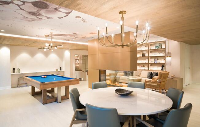 A thoughtfully designed clubroom with billiards, fireplace seating, and flexible gathering space at Modera Liberty Row.