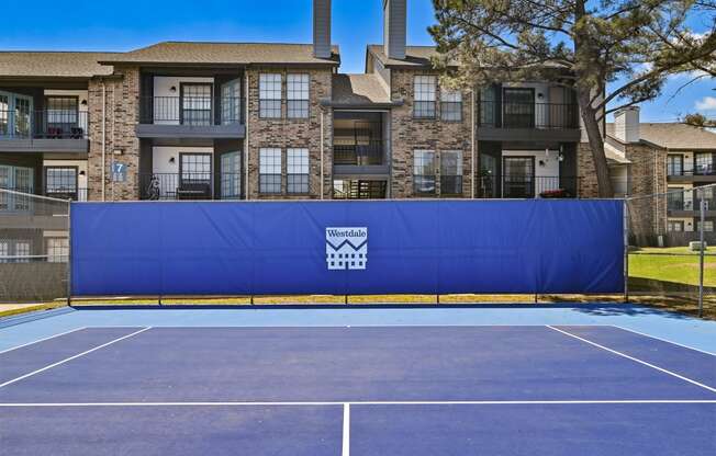 an outdoor tennis court at the enclave at woodbridge apartments in sugar land, tx