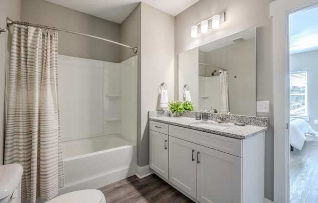 a bathroom with a large mirror and a shower and a sink