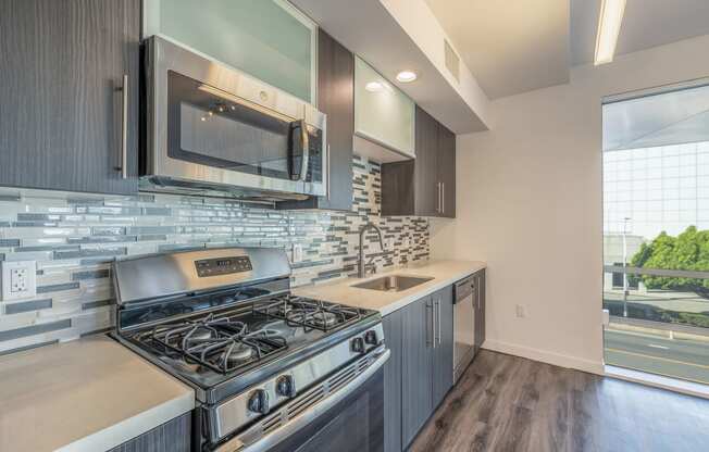 a kitchen with a stove and microwave and a sink