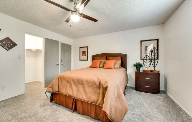 the master bedroom has a large bed and a ceiling fan