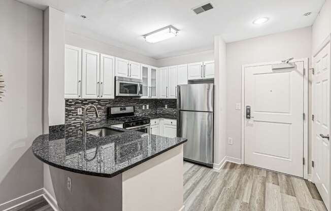 a kitchen with granite counter tops and stainless steel appliances