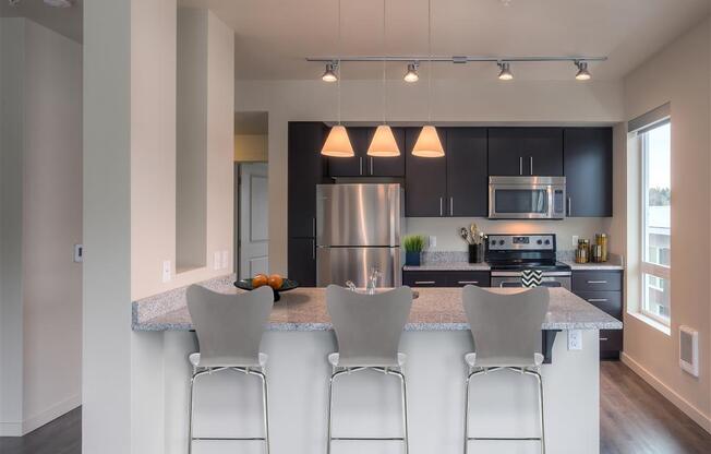 A kitchen with a refrigerator, microwave, oven, and sink. at Kirkland Crossing Apartments, Kirkland, WA