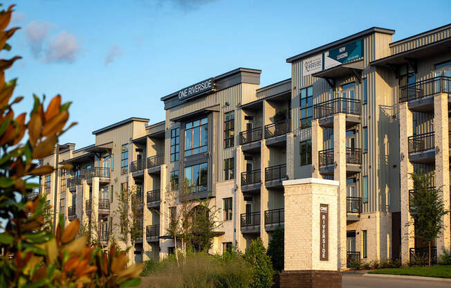 a row of apartment buildings with trees in the foreground  at One Riverside Apartments, Tennessee