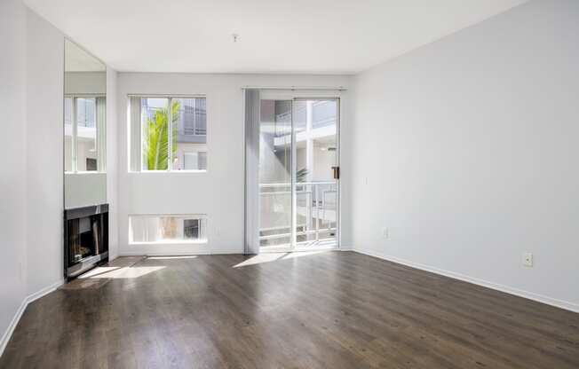 an empty living room with a fireplace and sliding glass doors