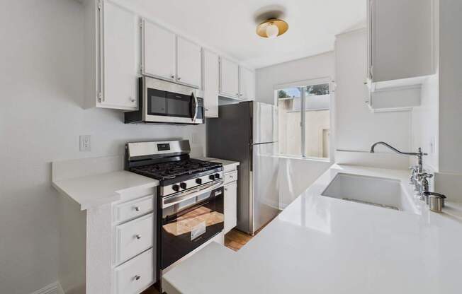 A white kitchen with a black stove and a black refrigerator.