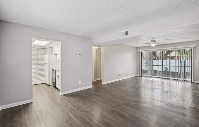 A spacious room with wooden floors and white walls.