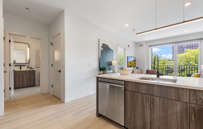 a kitchen with an island and a door to a living room