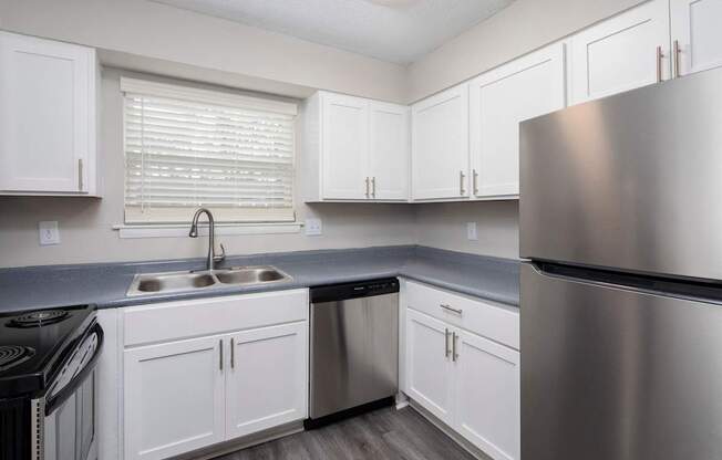 A kitchen with white cabinets and stainless steel appliances.