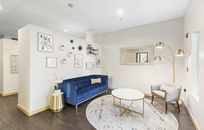 a living room with white walls and a blue couch at Guinevere Apartment Homes, Seattle, 98103