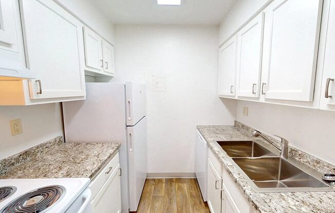 a kitchen with marble counter tops and white cabinets