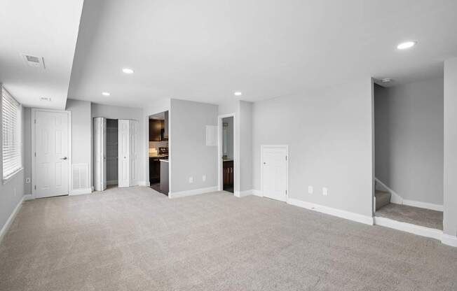 a living room with a carpeted floor and white walls