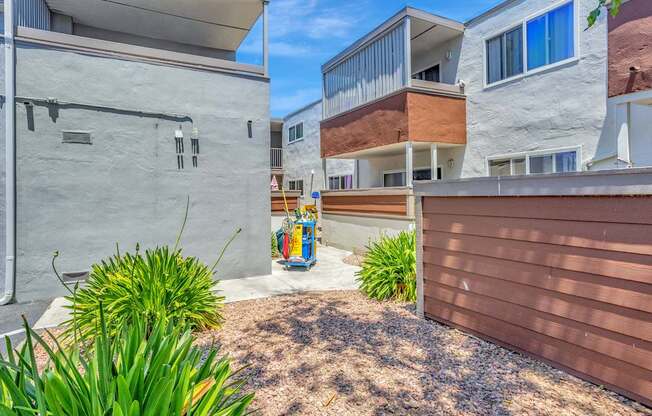 A modern building with a brown fence and a small garden in front.