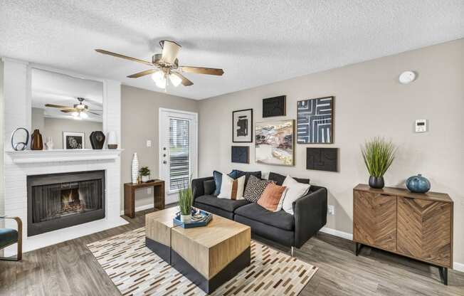 an open living room with a fireplace and a ceiling fan