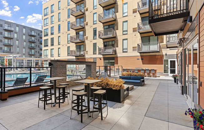 A patio with a table and chairs is surrounded by apartment buildings.