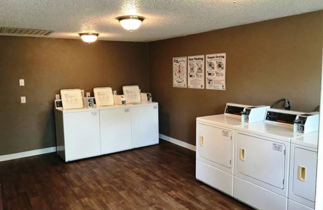 a laundry room with four washer and dryer machines
