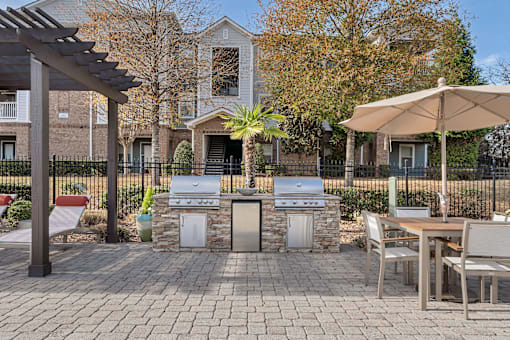 A patio with a table, chairs, and an umbrella.