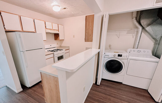 a kitchen with a washer and dryer and a refrigerator