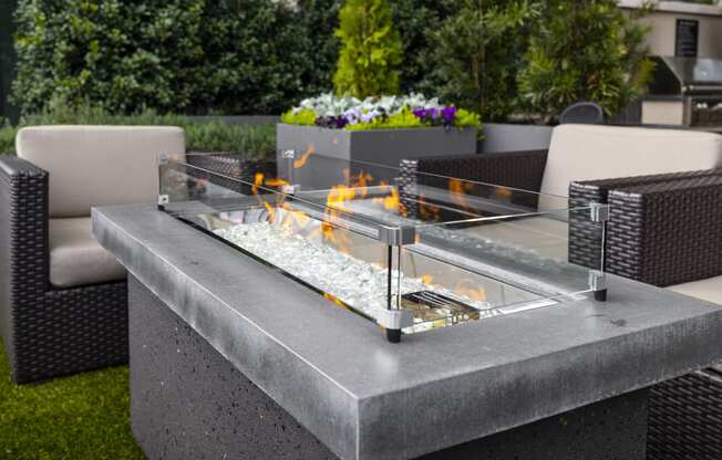 an outdoor table with a fire pit on top of it