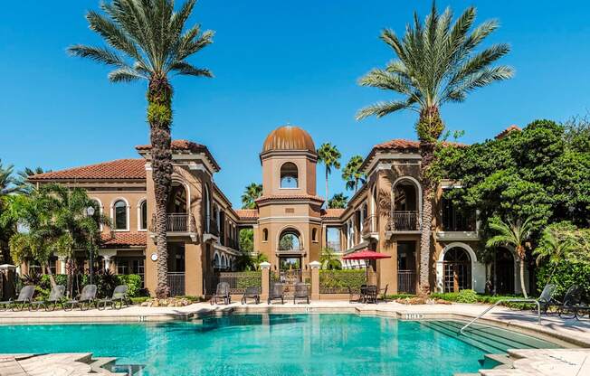 Grand pool courtyard framed by Mediterranean buildings and a central tower