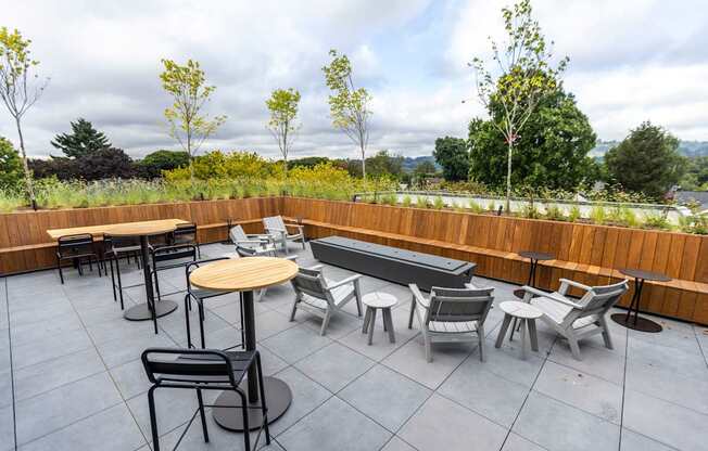 a rooftop patio with tables and chairs and a pool