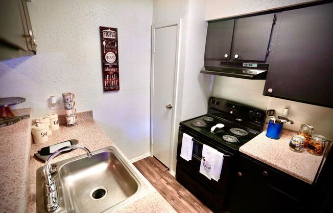 a kitchen with a stove top oven next to a sink