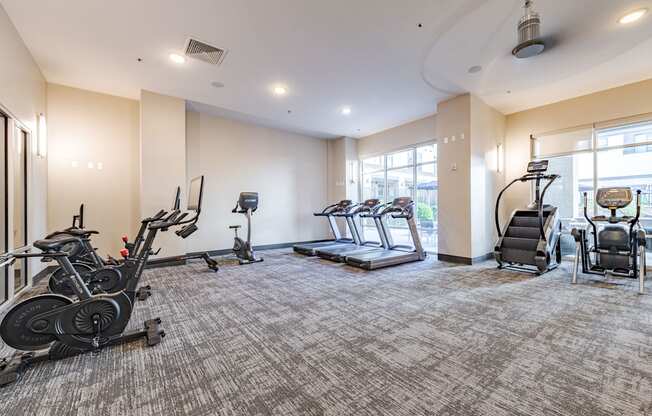 A spacious gym with treadmills, elliptical machines, and stationary bikes.