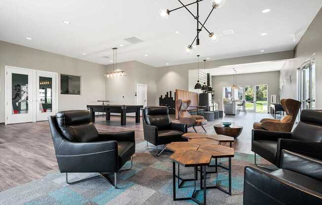 A modern living room with black leather furniture and a wooden coffee table.