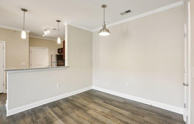 an empty living room with wood flooring and white walls