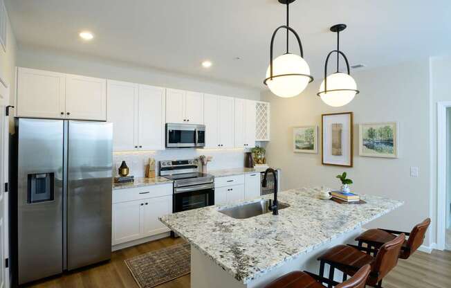 A kitchen with a granite countertop and stainless steel appliances.