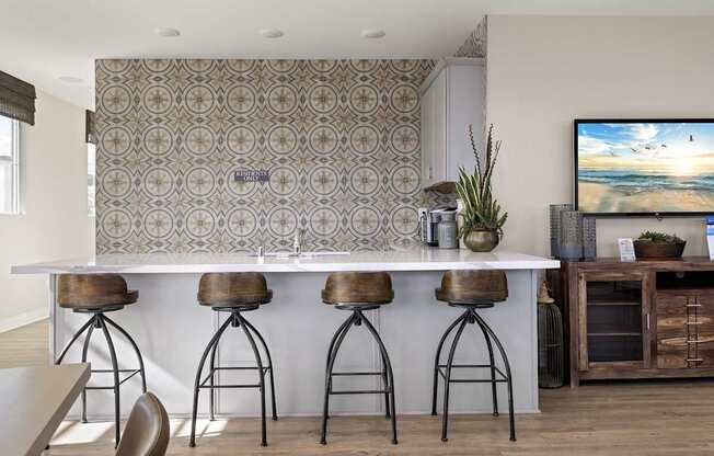 A modern kitchen with a bar area and a television mounted above it.