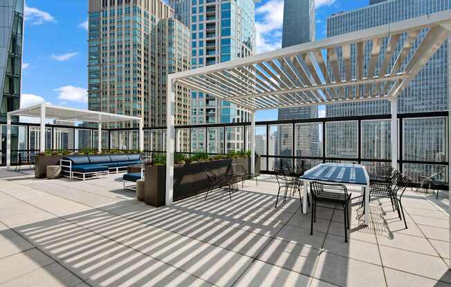 A rooftop patio with a table and chairs.