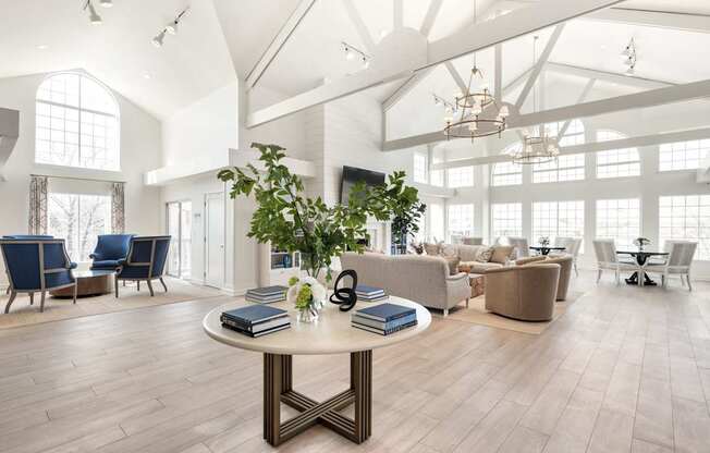 A spacious room with a round table in the center and chairs surrounding it.