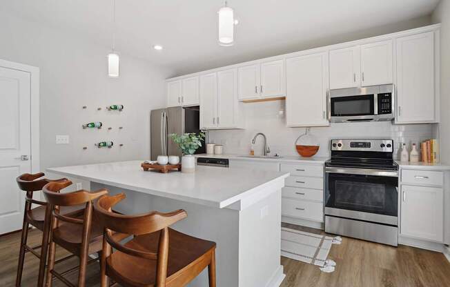 A kitchen with white cabinets and a white island with a counter top. at Zora University, Charlotte