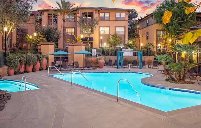 A large outdoor swimming pool surrounded by a fence and trees.