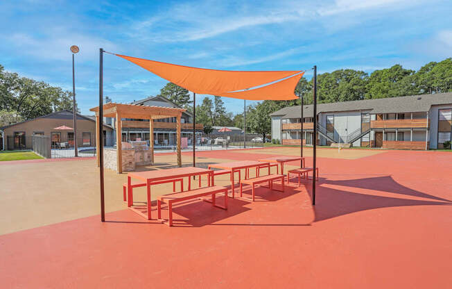 Picnic benches and a communal barbeque in a paved area at The Marq in Shreveport, LA
