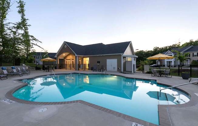 A large swimming pool in front of a house.