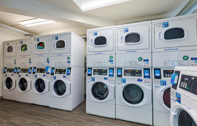 A row of white washing machines in a laundromat.