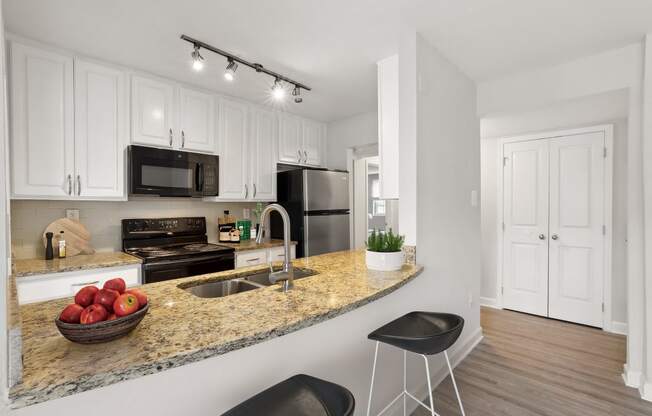 a kitchen with white cabinets and a granite counter top and a sink