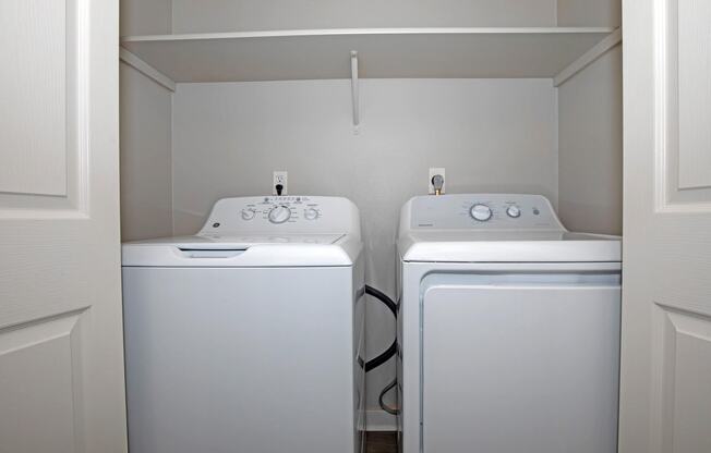 a laundry room with two washers and a dryer