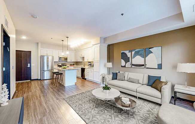 A modern living room with a kitchen in the background.