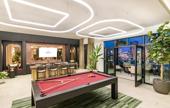 A sky lounge designed to impress—with skyline views, a billiards table, and bar seating perfect for entertaining.
