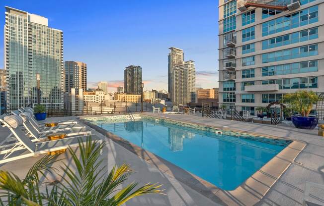 a pool with a city skyline in the background at the ace hotel