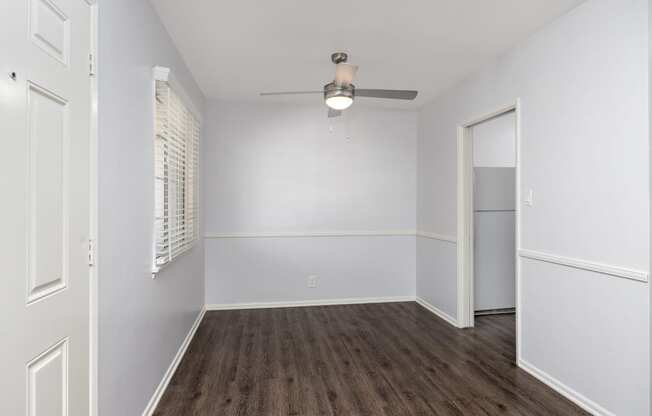 an empty bedroom with white walls and wood flooring and a closet