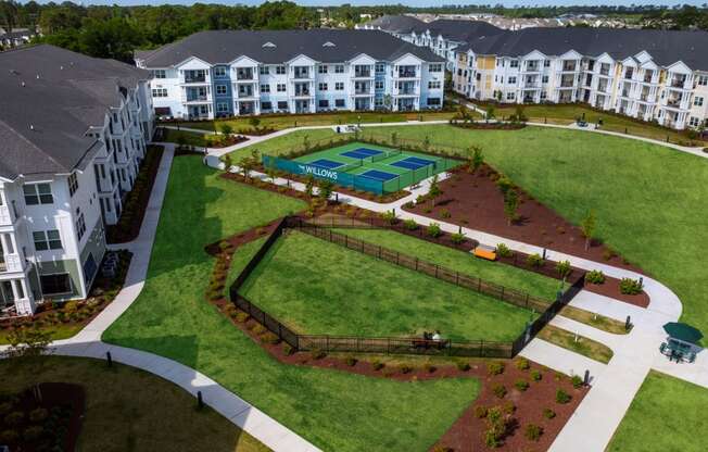 an aerial view of a park with apartments in the background