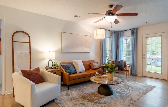 a living room with couches and a coffee table and a ceiling fan