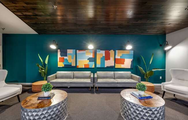 a lobby with couches and tables and a colorful wall