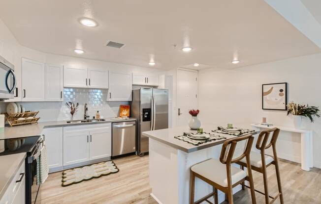 a kitchen with white cabinetry and stainless steel appliances